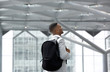 © mimagephotos - Young man smiling with bag at airport