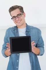 Poster - Nerdy businessman showing tablet pc smiling at camera