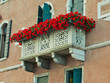 Arched window with balcony and flowers in Venice, Italy.
