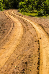 Wall Mural - Traces of wheeled vehicles used in agriculture on a dirt road.