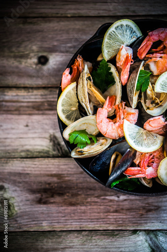 Photographie Mélange de moules, palourdes et crevettes sur fond de bois