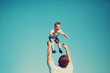 © guas - Happy father and son having fun, dad throwing child in the air outdoors, blue sky background, vintage photo