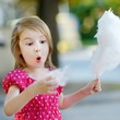 © MNStudio - Adorable little girl eating candy-floss outdoors