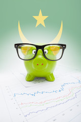 Piggy bank with flag on background - Mauritania