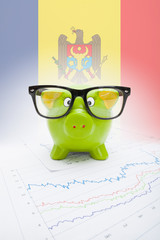 Piggy bank with flag on background - Moldova