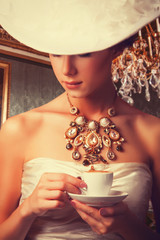 Poster - Portrait of redhead edvardian women with cup on red background.