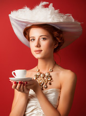 Poster - Portrait of redhead edwardian women with cup on red background.