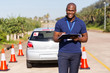 © michaeljung - african american driving instructor writing on clipboard