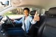 © michaeljung - young african female driver giving thumb up