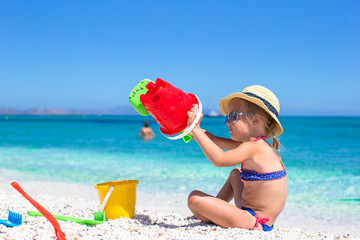 Adorable little girl playing with toys on beach vacation