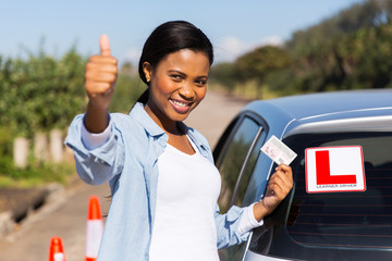 african learner driver holding her driver's license