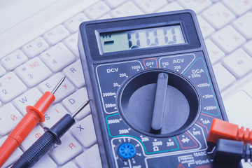 multimeter on the white laptop. close-up