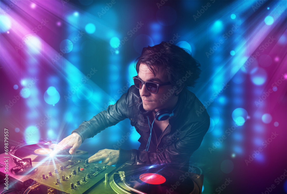 Dj mixing music in a club with blue and purple lights - obrazy, fototapety, plakaty 