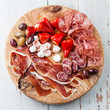 Cold meat plate and olives on wooden background