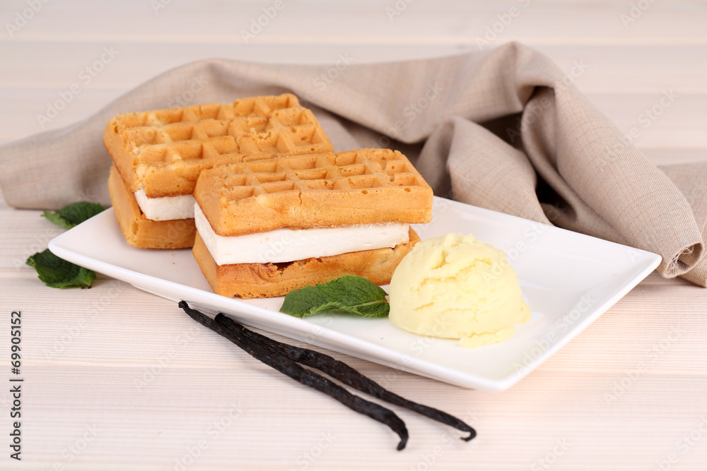 Tasty belgian waffles with ice cream on wooden table