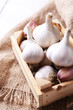 Fresh garlic in box, on wooden background