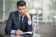 © elnariz - Focused businessman thinking and writing outside office
