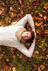 Canvas Print - smiling young man lying on ground in autumn park