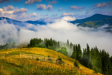 Wall Mural - amazing mountain landscape with fog and a haystack