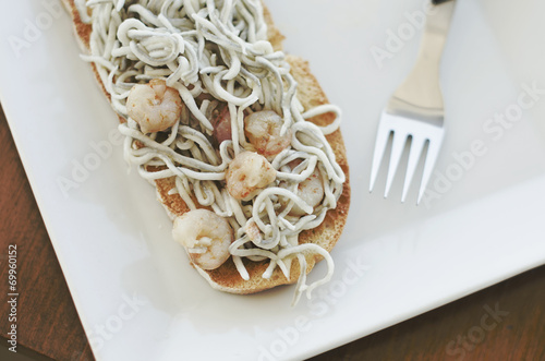 Fotomural Tostadas de gulas de surimi con gambas y ajos