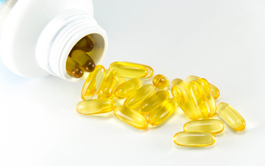 Vitamin Omega-3 fish oil capsules near a bottle