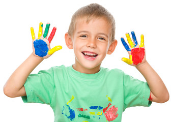 Portrait of a cute boy playing with paints