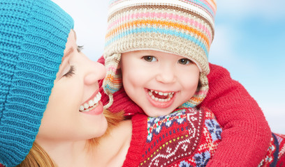 Poster - happy family mother and baby daughter playing in winter