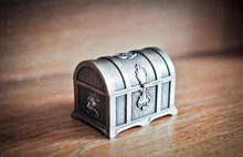 Old Silver Chest Isolated On Wooden Table. Closed Metallic Box