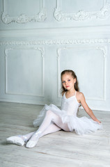 Wall Mural - A little adorable young ballerina in a playful mood in the inter