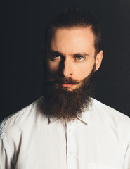 Young handsome man in white shirt on black background