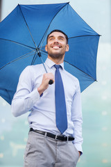 Sticker - young smiling businessman with umbrella outdoors