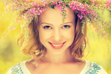 Wall Mural - beautiful happy Slavic girl in a wreath of summer flowers