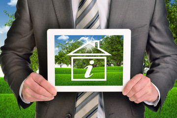 Two hands holding tablet pc with picture of house icon