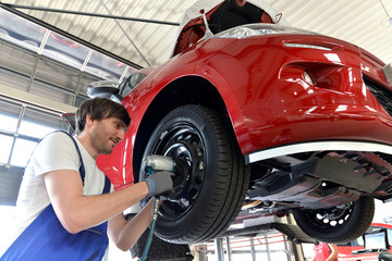 Wall Mural - Reifenwechsel in einer KFZ Werkstatt // Tire change by mechanic