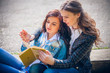 © Andriy Petrenko - students sitting with a book on street