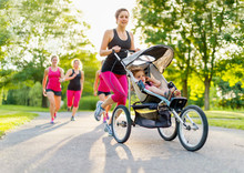 Active Mother Jogging In Park With Stroller
