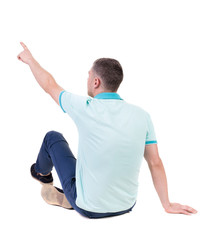 Canvas Print - Back view of  pointing young men in  shirt and jeans.