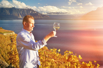 Wall Mural - Man holding a glass of wine. Lavaux, Switzerland