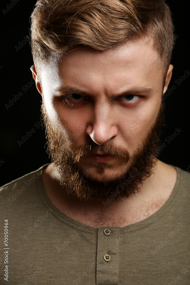 Portrait of handsome man with beard on black background