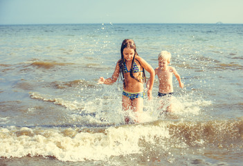 happy little girl and boy in the sea