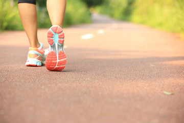 Poster - young fitness woman legs running at forest trail 