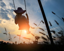 Woman Playing On A Swing At Sunset