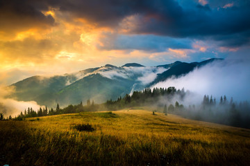 Amazing mountain landscape with fog and a haystack