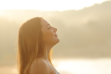 Poster - Woman breathing deep fresh air in the morning sunrise