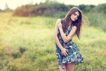 beautiful brunette in a field on a sunny day