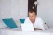 © Di Studio - man in bathrobe with laptop in hotel room