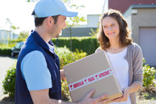 Delivery Man Handing Over A Parcel To Customer