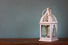 White Lantern Over Wooden Table