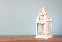 White Lantern Over Wooden Table