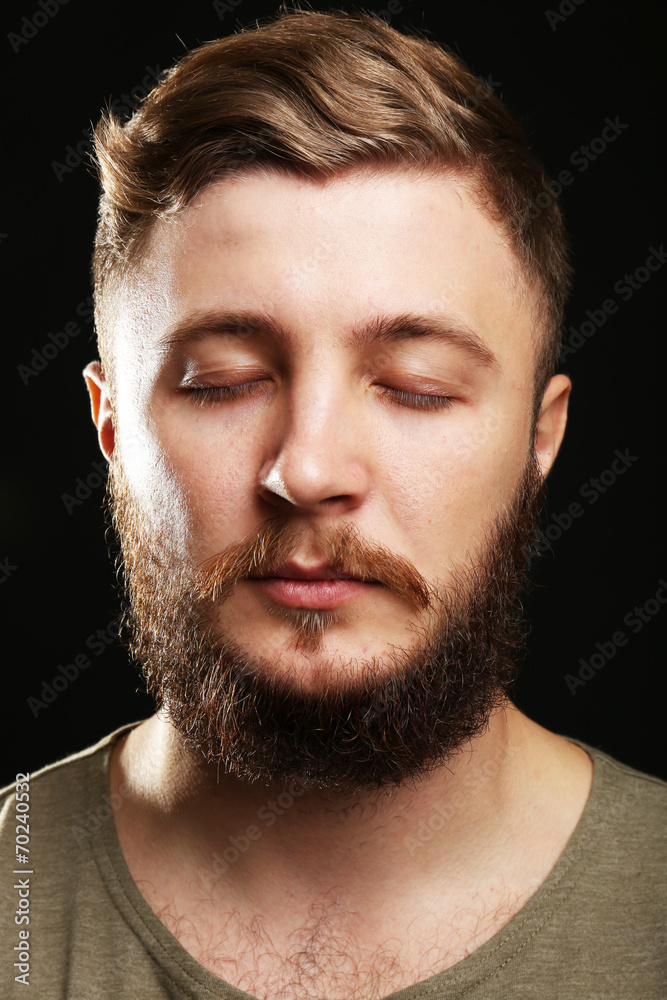 Portrait of handsome man with beard on black background